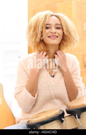 Crea la tua musica. Battendo il ritmo dei tamburi. Bongo, percussione. Ragazza che gioca i tamburi di bongo, tamburi piccoli. Foto Stock