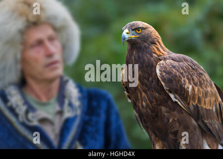 Il kazako eagle hunter in costumi tradizionali e il suo golden eagle ad Almaty in Kazakistan. Foto Stock