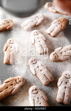 Gingerbread Man essendo spolverato di zucchero a velo Foto Stock