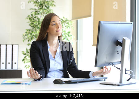 Carefree imprenditrice rilassarsi facendo esercizi yoga in ufficio Foto Stock