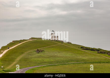 Belle Toute Lighthouse. Faro di Beachy Head con la verde collina di percorsi e di gente che passeggia lungo il fronte delle scogliere. Foto Stock