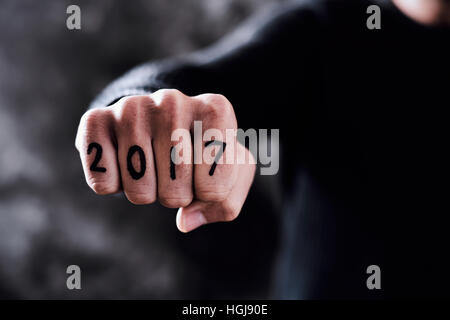 Primo piano del pugno di un giovane con il numero 2017, come il nuovo anno, scritto in le sue dita Foto Stock