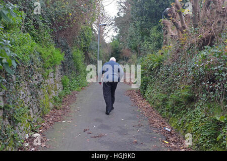 Un vecchio uomo cammina lungo un percorso in Cornwall, Regno Unito Foto Stock