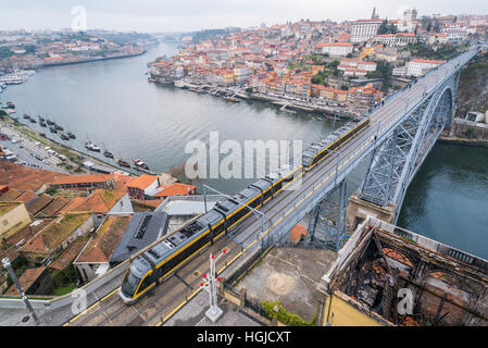 Un tram capi sopra il famoso Dom Luís I bridge in porto in una giornata grigia Foto Stock