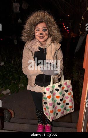 Teen donna in costume gatto raccoglie Halloween Candy in una notte di Dolcetto o scherzetto. St Paul Minnesota MN USA Foto Stock