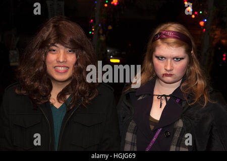 Teens fuori per la festa di Halloween divertente come un interprete femminile e una donna zombie con il sangue dalla sua bocca. St Paul Minnesota MN USA Foto Stock