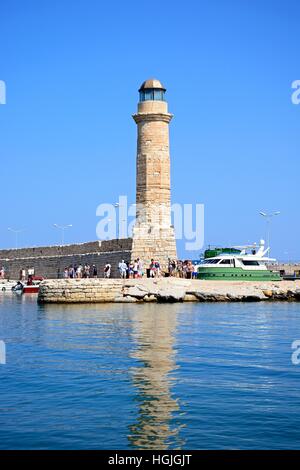 Vista del faro con i turisti a piedi lungo la parete del porto, Rethimno, Creta, Grecia, l'Europa. Foto Stock