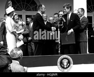 Presidente degli Stati Uniti John Fitzgerald Kennedy si congratula con l'astronauta Alan B.Shepard Jr., il primo americano nello spazio, nel suo storico 5 maggio 1961 cavalcata in libertà 7 veicoli spaziali e lo presenta con la Nazionale Aeronautica e Spaziale Administration (NASA) Distinguished Service Award, a Washington il 6 maggio 1961. Shepard la moglie Louise (a sinistra in abito bianco e hat), e sua madre erano in presenza così come gli altri sei astronauti Mercury, tra cui il colonnello John H. Glenn, Jr. e altri agenti della NASA, visibili alcuni in background.Credit: la NASA via CNP - nessun filo SERVICE - foto: n Foto Stock