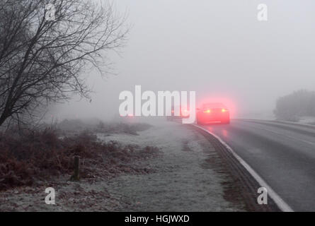 Godshill, New Forest, Hampshire, Regno Unito. 23rd Gennaio 2017. Meteo. Guida in nebbia. I fendinebbia dell'auto brillano grazie alla fitta nebbia gelida che rende pericolose le condizioni di guida per i conducenti in una mattinata d'inverno. Foto Stock