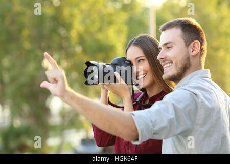 Fotografo imparare in un corso di fotografia all'aperto ascoltando il Maestro spiegazione Foto Stock