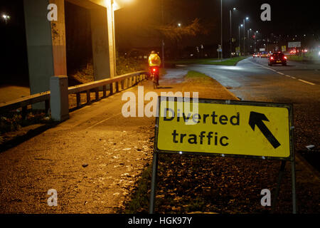 Traffico deviato firmare con il ciclista sulla bicicletta il traffico di notte e la Great Western Road Foto Stock