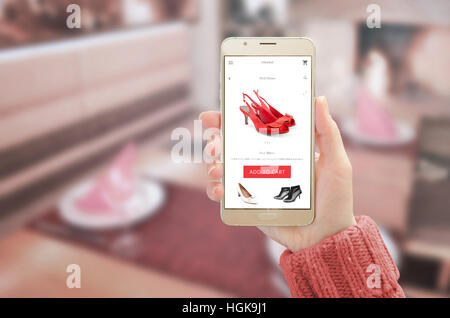 La donna che mostra d'oro moderne smart phone con shopping online app sul dispositivo di visualizzazione. Donna scarpe di colore rosso e il pulsante Aggiungi al carrello. Foto Stock