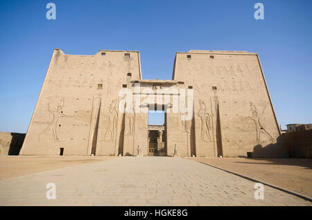 L'entrata principale del Tempio di Edfu che mostra il primo pilone, dedicato al dio falco Horus, situato sulla sponda occidentale del Nilo, Edfu, Alto Egitto Foto Stock