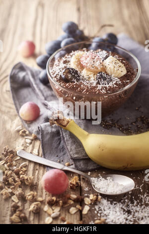 Cioccolato budino di Chia con frutta in recipiente di vetro sul tavolo di legno Foto Stock