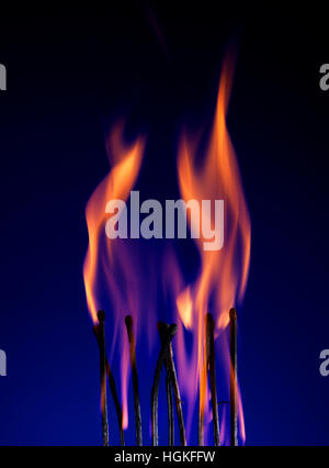 Ripresa macro di una fiammante matchstick su blu Foto Stock