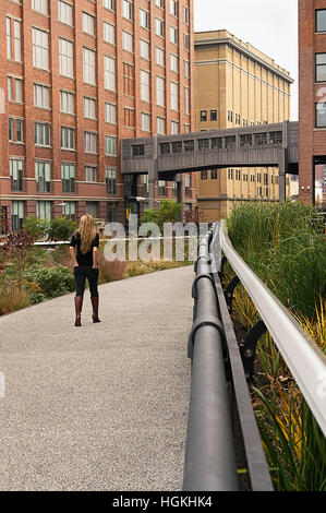 Una donna che cammina sulla linea alta nella città di New York Foto Stock