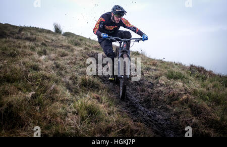 Un mountain biker, cavalca un sentiero su una collina gallese nel Regno Unito per la sua moderna full suspension bike. Foto Stock