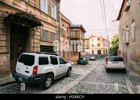 Tbilisi, Georgia - 20 Maggio 2016: la vista posteriore del bianco parcheggiata Nissan Xterra SUV auto vicino all'antico edificio sulla discesa stretta strada di ciottoli in su Foto Stock