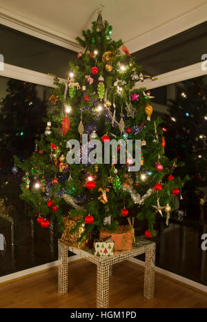 Ben decorate albero di Natale sulla tavola con presenta dalla finestra. Foto Stock