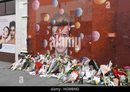 Omaggi floreali di David Bowie a sinistra da appassionati al murale di Brixton nel primo anniversario della sua morte,Brixton,London.UK Foto Stock