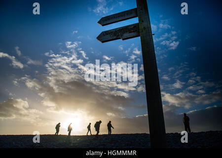 Aberystwyth Wales UK, mercoledì 11 Jan 2016 UK meteo: un gruppo di persone a piedi lungo il Ceredigion sezione del Galles sentiero costiero a spiaggia Tanybwlch Aberystwyth, come il sole che irrompe attraverso le nuvole prima della tempesta bagnato e innevato eventualmente meteo spazia verso il basso dal nord per tutta la notte foto © Keith Morris / Alamy Live News Foto Stock