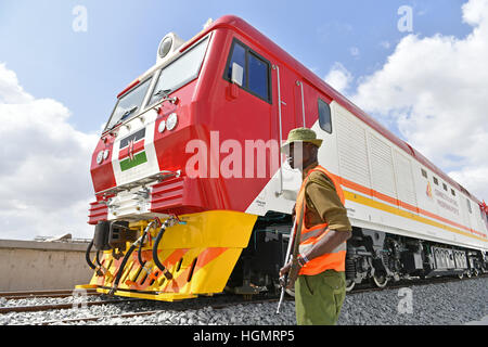 Mombasa, in Kenya, 12 gennaio, 2017. Un uomo sta di guardia durante la cerimonia di accoglienza del primo lotto di locomotori per il Mombasa-Nairobi ferrovia a Mombasa, in Kenya, il 11 gennaio 2017. Il Kenya ha ricevuto 6 locomotori da Cina, che si correrà su una Cina-finanziato ferrovia (SGR) a causa di inizio funzionamento di prova in giugno a Mombasa, in Kenya. Credito: Xinhua/Alamy Live News Foto Stock