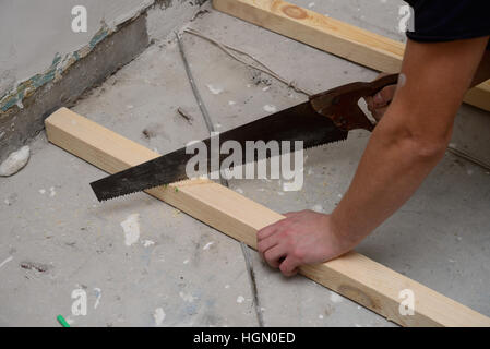 Dettaglio di un uomo il taglio di legno con una piccola sega a mano Foto Stock