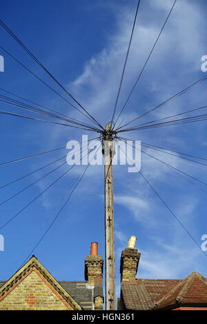 Linee telefoniche attaccato al palo del telegrafo sopra le case di Londra Foto Stock