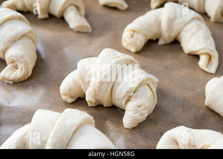 Croissant fatti in casa a forma di pasta e salita prima di essere cucinati Foto Stock