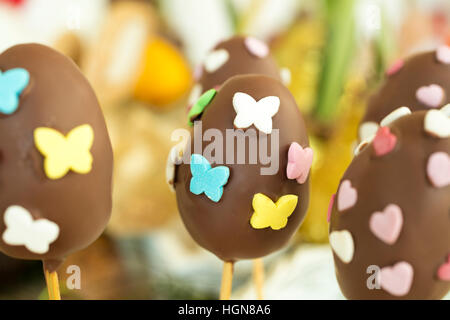 Dettaglio delle uova di pasqua di cioccolato con il cuore e con la forma a farfalla caramelle. Foto Stock