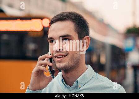Giovane uomo parlando su un cellulare nella città Foto Stock