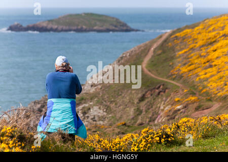 Fotografo che scatta foto al promontorio di Porthclais vicino a St Davids al Pembrokeshire Coast National Park, Galles UK, a maggio Foto Stock