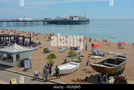 La passeggiata sul lungomare e la spiaggia di Brighton in East Sussex, Inghilterra. Con un sacco di persone Foto Stock