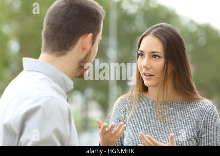 Giovane parlando all'aperto in un parco con uno sfondo verde Foto Stock