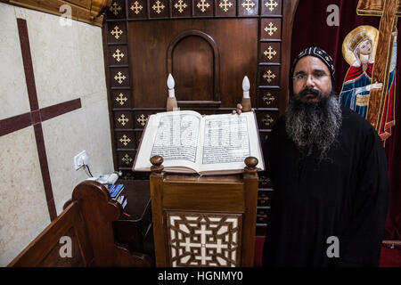 Gerusalemme, Israele - Agosto 1,2014: monaco copto e un nuovo Testamento Bibbia scritta in lingua copta nel Patriarcato copto in Gerusalemme, accanto a t Foto Stock