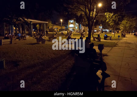 L'Avana, Cuba. Il popolo cubano tramite telefono cellulare, telefono cellulare, smartphone e tablet ipad per internet wi-fi in un parco di Miramar Foto Stock