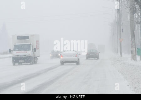 Bucarest, Romania, 25 gennaio 2016: sono vetture che passa su una strada innevata durante una bufera di neve a Bucarest. Foto Stock