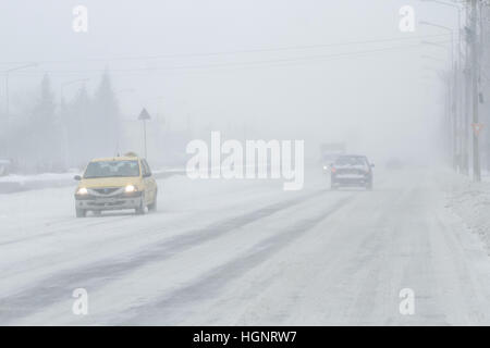 Bucarest, Romania, 25 gennaio 2016: sono vetture che passa su una strada innevata durante una bufera di neve a Bucarest. Foto Stock