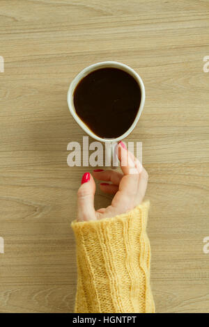 Donna con mano manicure rosso sta per prendere una tazza di caffè Foto Stock