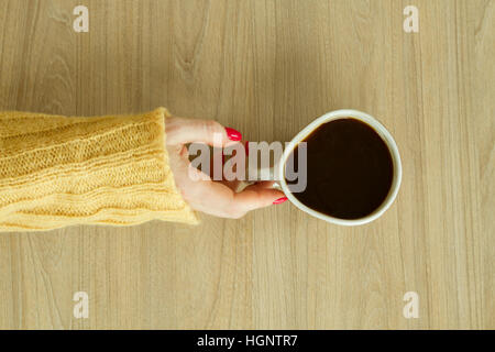 Donna con mano manicure rosso sta per prendere una tazza di caffè Foto Stock