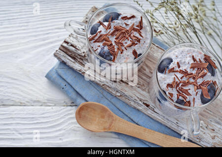 Budino di Chia con uva e scaglie di cioccolato sul bianco tavolo in legno vista superiore Foto Stock