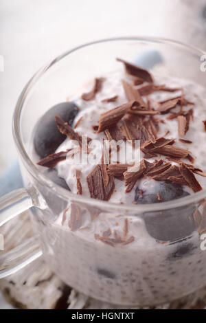 Budino di Chia con uva e scaglie di cioccolato in tazza di vetro Foto Stock