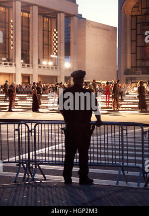 New York Police Officer guardando l apertura di una sfilata di moda durante la settimana della moda di New York Foto Stock