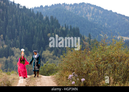 Il kazako matura in costumi nazionali camminando mano nella mano, ad Almaty in Kazakistan Foto Stock