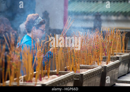 Joss bastoni e adoratore a Sik sik Yuen Wong Tai Sin Temple, Hong Kong Foto Stock