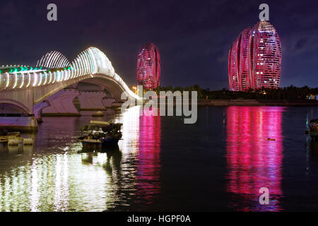 Phoenix Island Resort e complesso di appartamenti illuminata di notte nel porto di Sanya Foto Stock