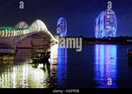 Phoenix Island Resort e complesso di appartamenti illuminata di notte nel porto di Sanya Foto Stock