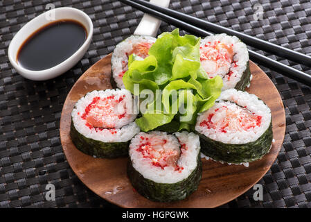 Chiudere fino a cinque pezzi di rotoli Futomaki servite sul piatto di legno con la salsa di soia nel ristorante asiatico Foto Stock