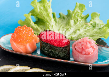 Vista ravvicinata di Gunkanmaki rotoli di sushi servita sulla piccola piastra oblunga Foto Stock