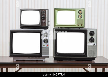 Quattro televisori vintage sulla tavola con tagliare fuori gli schermi. Foto Stock